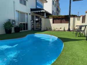 a blue swimming pool in the yard of a house at City Ville Apartments and Motel in Rockhampton