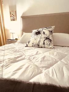 a white bed with a pillow on top of it at Suite Centro con COCHERA in Bahía Blanca
