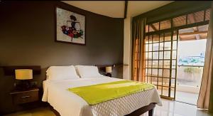 una camera da letto con un letto con una coperta gialla sopra di HOTEL MANTA BEACH MADRIGAL a Manta