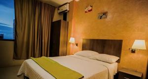 ein Schlafzimmer mit einem großen Bett und einer grünen Decke in der Unterkunft HOTEL MANTA BEACH MADRIGAL in Manta