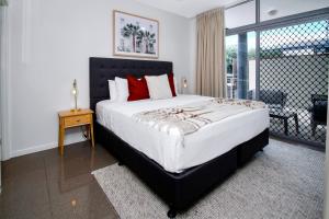 a bedroom with a large bed and a balcony at Stunning Ground Floor City Apartment 104 in Cairns