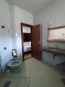a bathroom with a toilet and a sink at Recanto Pau Brasil in Sete Lagoas