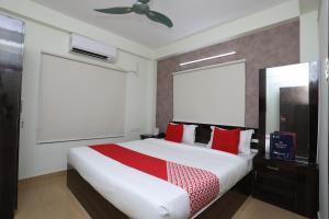 - une chambre avec un grand lit et des oreillers rouges dans l'établissement OYO Flagship 16892 The Resting Place, à Pānchuria