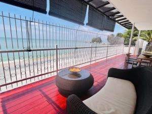 a balcony with a table and a view of the beach at Private Beach-front Haven by StayCo - Seaview Pool, KTV & Speaker System, Beach Air Loft, Private Beach Access and Beyond! in Tanjung Bungah