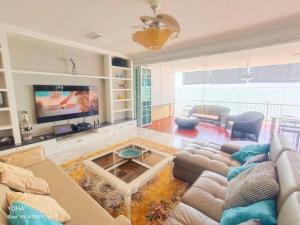 a living room with a couch and a tv at Private Beach-front Haven by StayCo - Seaview Pool, KTV & Speaker System, Beach Air Loft, Private Beach Access and Beyond! in Tanjung Bungah