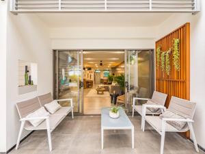 een woonkamer met witte stoelen en een tafel bij Stylish Townhouse near Fisherman in Nathon Bay