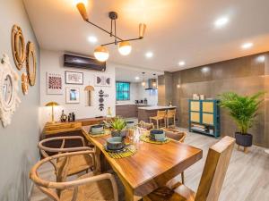 a dining room and kitchen with a wooden table and chairs at Stylish Townhouse near Fisherman in Amphoe Koksamui