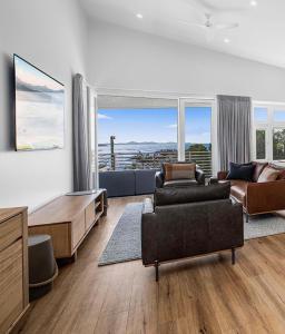 een woonkamer met een bank en een tafel en stoelen bij Bluehaven Woolgoolga - Brand New, Ocean Views, 200m Stroll to Beach and Restaurants! in Woolgoolga