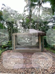 a monument in a garden with a sign on it at Flat Amarilis em Riviera São Lourenço - com arrumação, café manhã, wifi privat, toalhas praia e piscina e enxoval completo com trocas toalhas in Riviera de São Lourenço
