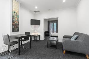 Comfort Hotel Melbourne Central في ملبورن: غرفة معيشة مع أريكة وطاولة