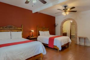 sypialnia z 2 łóżkami i wentylatorem sufitowym w obiekcie Atotonilco Hotel & Club w mieście Atotonilco