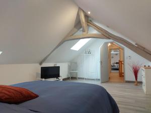 een slaapkamer met een bed en een tv op zolder bij Gîte Saint-Christophe, 4 pièces, 6 personnes - FR-1-581-116 
