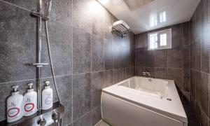 a bathroom with a sink and a bath tub at Anyang ILLOWA Hotel in Anyang