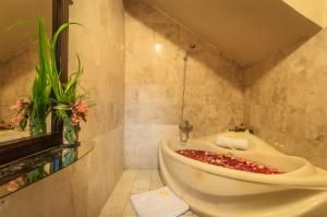 een badkamer met een bad en een wastafel bij Sahadewa Resort & Spa in Ubud