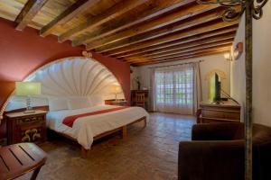 a bedroom with a large bed and a large window at Atotonilco Hotel & Club in Atotonilco