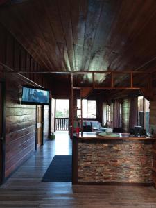 een woonkamer met een bar en een tv aan een bakstenen muur bij Chalet El Riachuelo in La Suiza