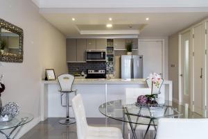 Una cocina y una sala de estar con una mesa de cristal y sillas. en Luxury Kingston Apt - Pool & free parking 20 south, en Kingston