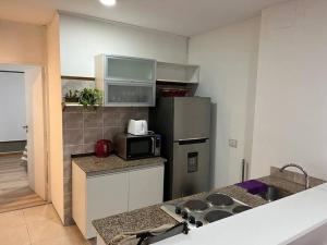 a kitchen with a stove and a microwave in it at Precioso Departamento en Caballito in Buenos Aires