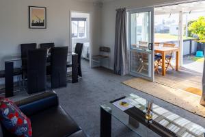 a living room with a couch and a table at Tui nest in Whangamata