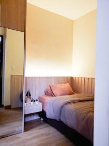 ein Schlafzimmer mit einem großen Bett und einem Spiegel in der Unterkunft RT House Cozy Homestay 2BR Podomoro Golf View in Taladjurg-udik