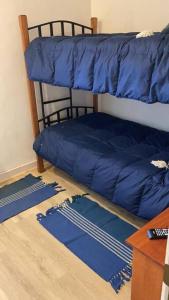Etagenbett mit blauem Kissen auf dem Boden in der Unterkunft Departamento San Alfonso del mar in San Antonio