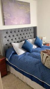 ein Schlafzimmer mit einem blauen Bett mit blauen Kissen in der Unterkunft Departamento San Alfonso del mar in San Antonio