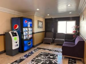 uma sala de espera com uma máquina de refrigerantes e um sofá em The Patio Motel - Los Angeles, LAX em Gardena