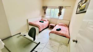 a small room with two beds and a window at Homely 3 bedroom apartment perfect for your dream getaway! in Port Vila +6 photos