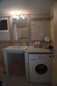 een badkamer met een wasmachine en een wastafel bij Cristina‘s Place in Heraklion