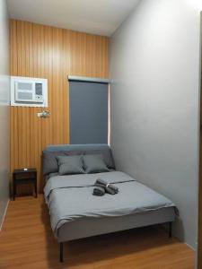 a bed with two shoes on it in a room at Stylish 2BR w/ Free Pool Access and Parking LG03 in Manila
