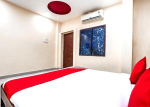 een slaapkamer met een bed en een raam bij OYO Flagship Sathya Inn in Warangal