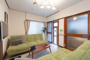 a living room with a couch and a table at Honmachi House in Tokyo