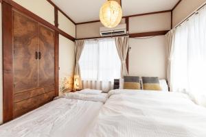 a bedroom with a large bed and a window at Honmachi House in Tokyo