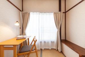 a room with a desk and a window with a chair at Honmachi House in Tokyo