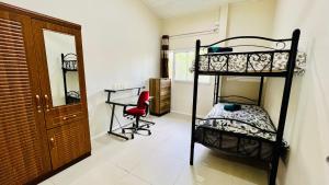 1 dormitorio con 2 literas y silla roja en Homely 3 bedroom apartment perfect for your dream getaway! en Port Vila