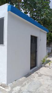 un edificio blanco con techo azul y puerta en Apartamento ideal y acogedor en Mérida