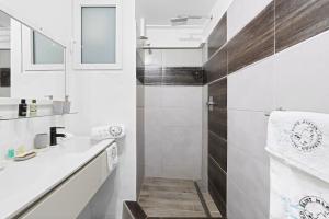 a white bathroom with a sink and a shower at Beyond Seas Studio in Saint Martin