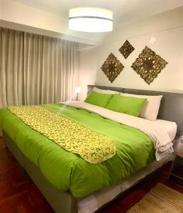 a bedroom with a large bed with green sheets at Cusco Magico 7 - Minidepartamento Las Torres Kayser in Cusco