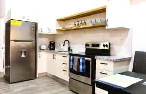 a kitchen with a stainless steel refrigerator and white cabinets at Discounted - Hermosa Paradise Mins from beach in Playa Hermosa