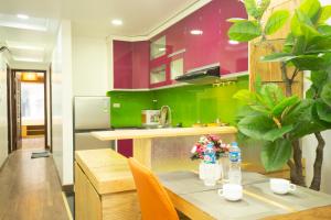 Sumitomo12- 535 Kim Mã Apartment for Japanese في هانوي: مطبخ مع طاولة خشبية ودواليب خضراء