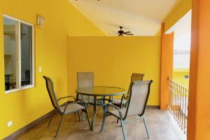 een eetkamer met gele muren en een tafel en stoelen bij Hermosa Paradise Mins From Beach in Playa Hermosa