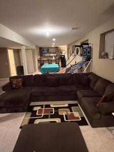 uma sala de estar com um sofá castanho e um tapete em Anthony apartment em Macomb