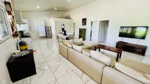 a living room with two couches and a tv at Homely 3 bedroom apartment perfect for your dream getaway! in Port Vila