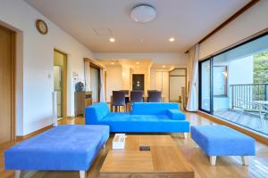 una sala de estar con sofás azules y una mesa. en スイートヴィラ 箱根強羅, en Gora
