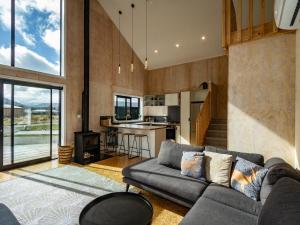 ein Wohnzimmer mit einem Sofa und einer Küche in der Unterkunft Viewtopia - Ohakune Holiday Home in Ohakune