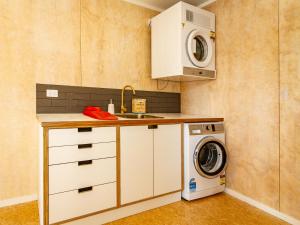 a kitchen with a washing machine and a sink at Viewtopia - Ohakune Holiday Home in Ohakune