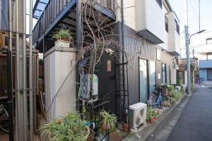 un edificio con una puerta negra con plantas. en KS west Waseda 1F, en Tokio