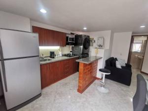 a kitchen with a white refrigerator and a stove at Acogedor Apto Parque Sabaneta in Sabaneta
