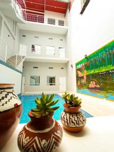 dos jarrones sentados en una mesa junto a una piscina en La Quinta Loft Apartments, en Iquitos