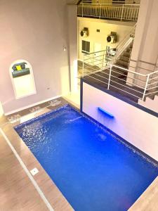 a swimming pool with blue water in a building at La Quinta Loft Apartments in Iquitos